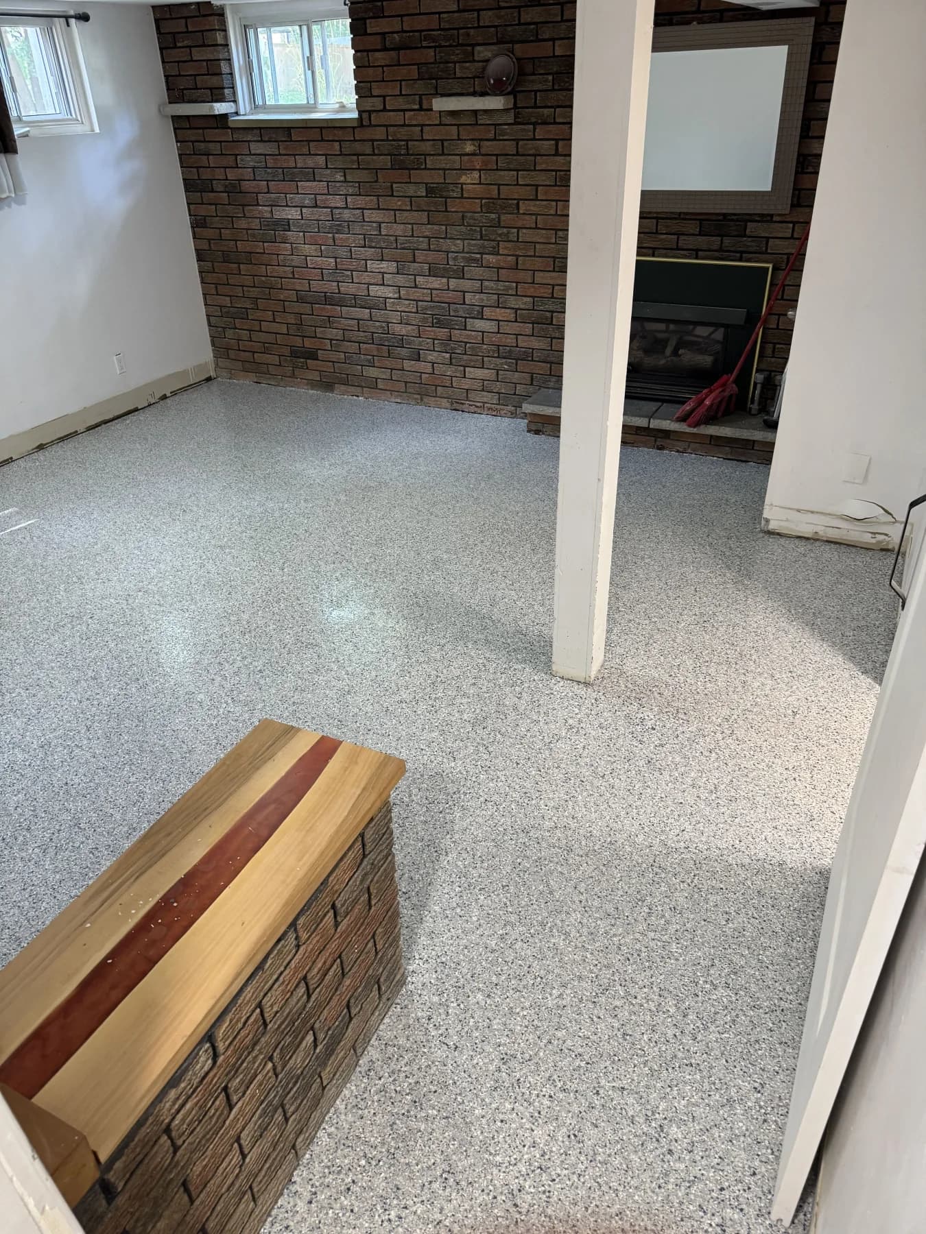 SolidBase grey flake basement floor with a brick fireplace and white support column