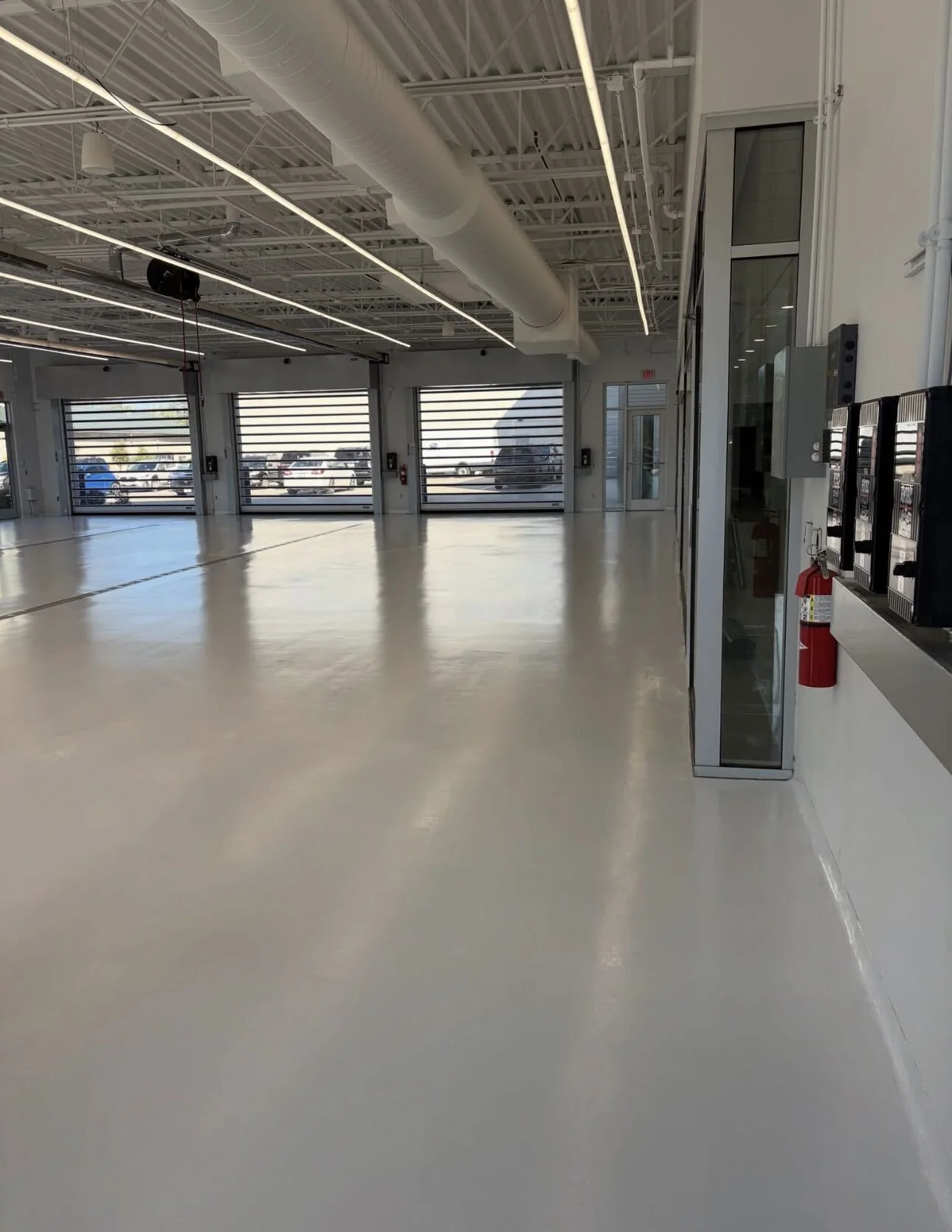 SolidBase grey commercial floor finish in automotive service bays with glass garage doors
