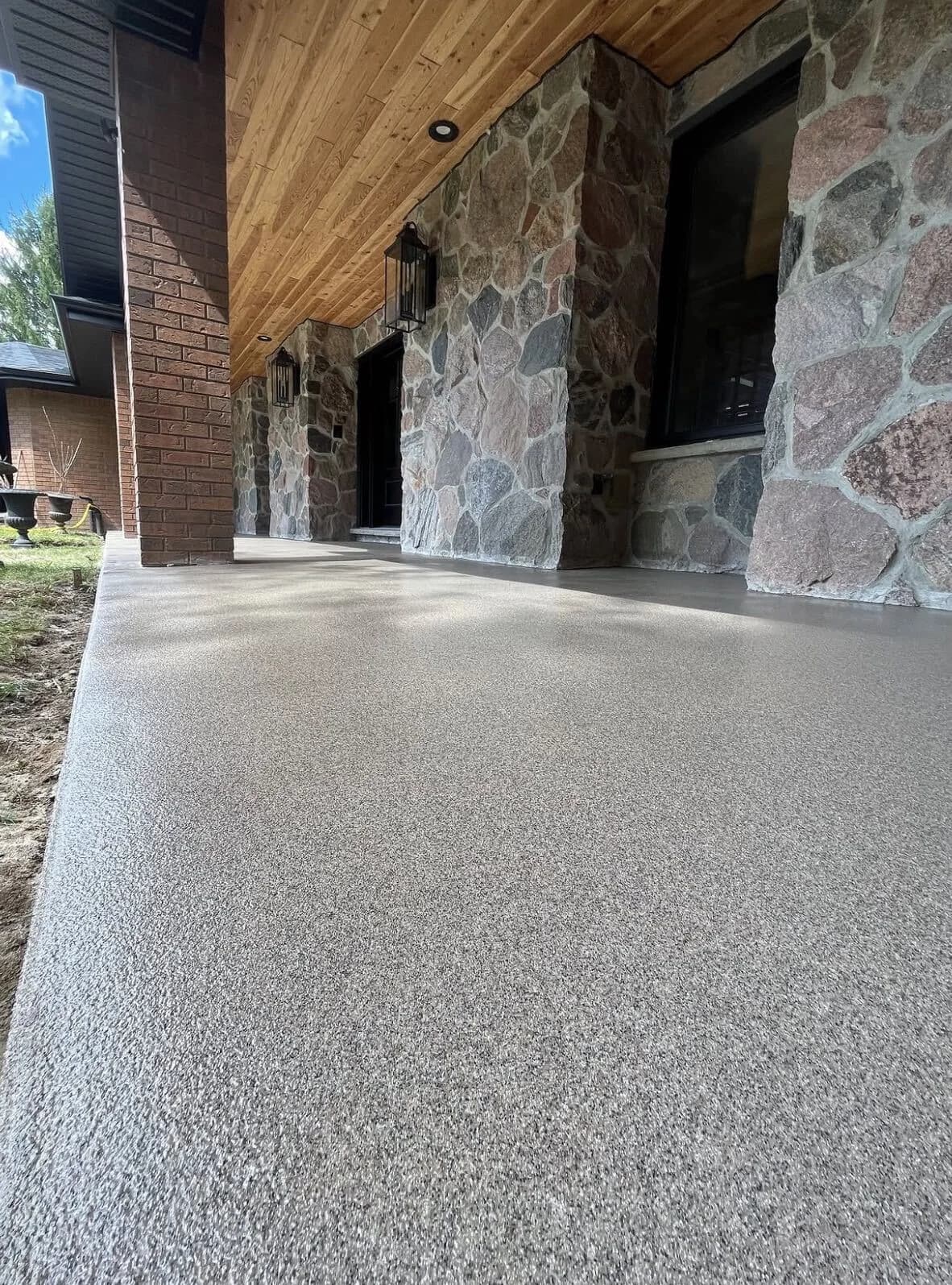 SolidBase grey flake porch coating beside natural stone walls and a timber ceiling